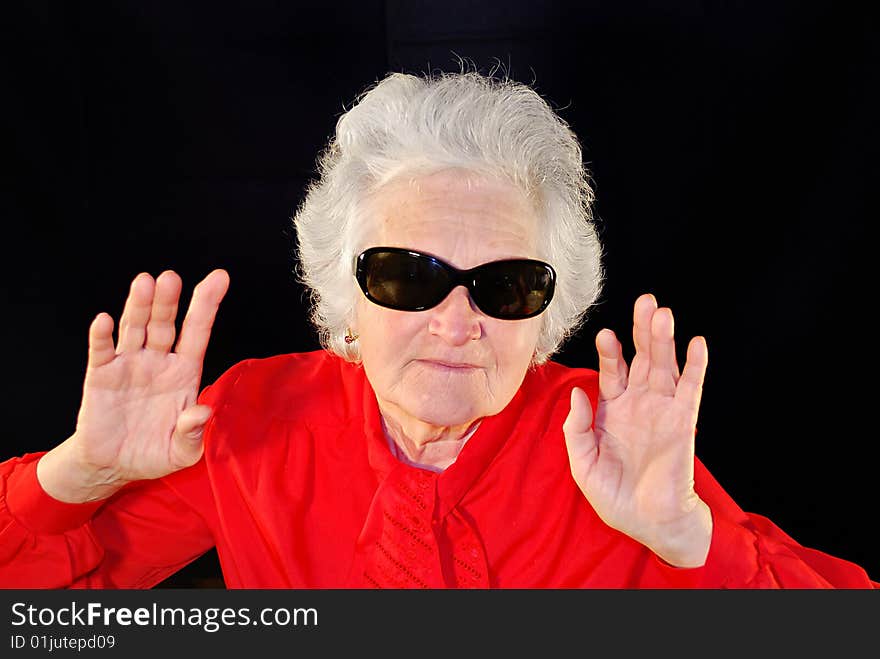 A portrait of elderly woman in red and in antisun glasses