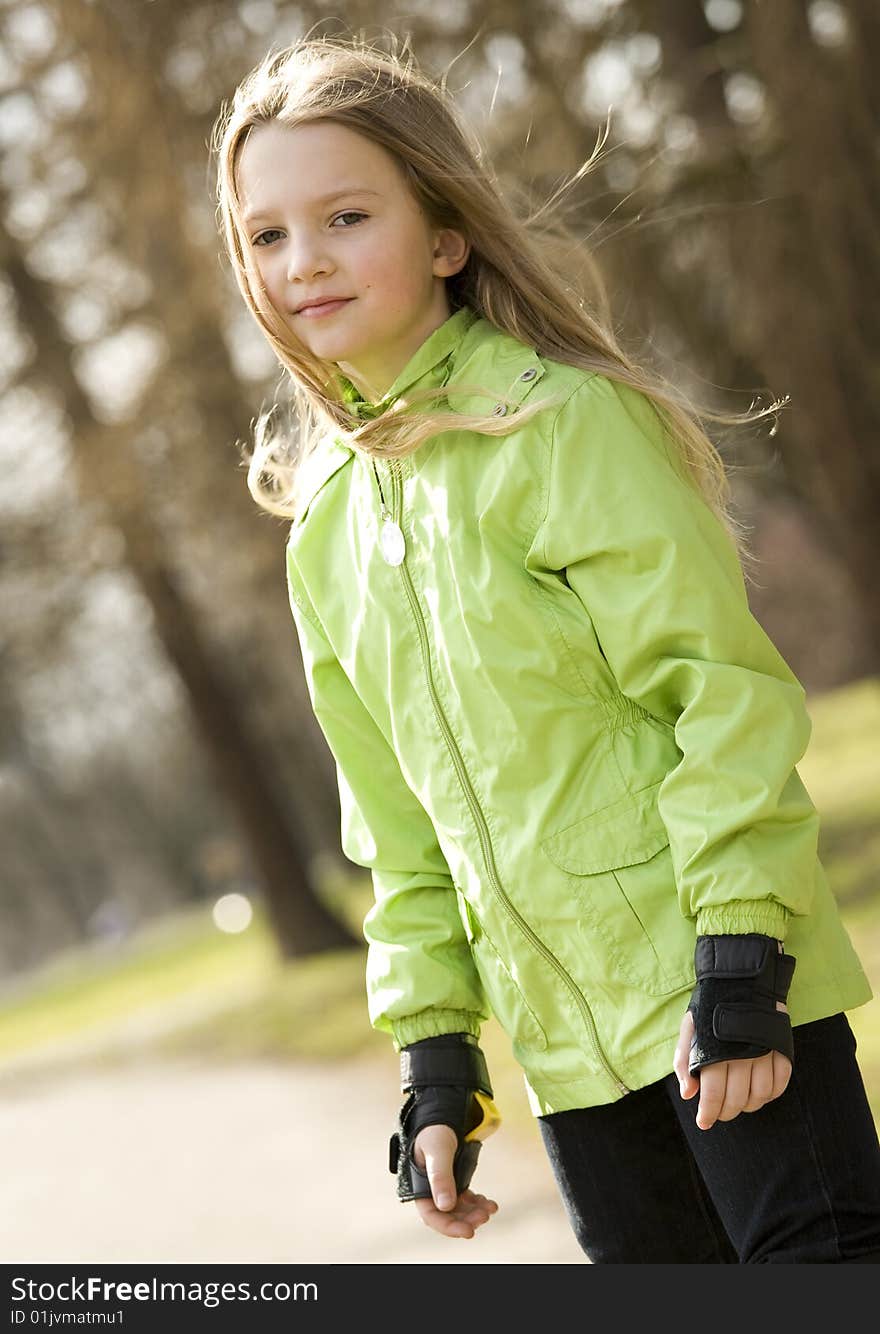 Cute little girl on roller-skates. Blurry background. Cute little girl on roller-skates. Blurry background