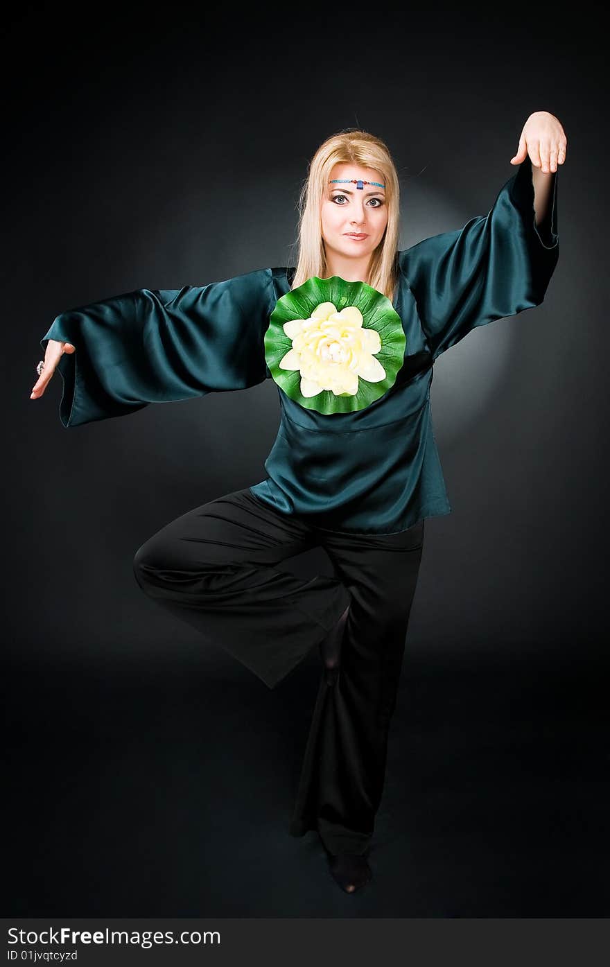 Woman with lotus exercising, studio shot