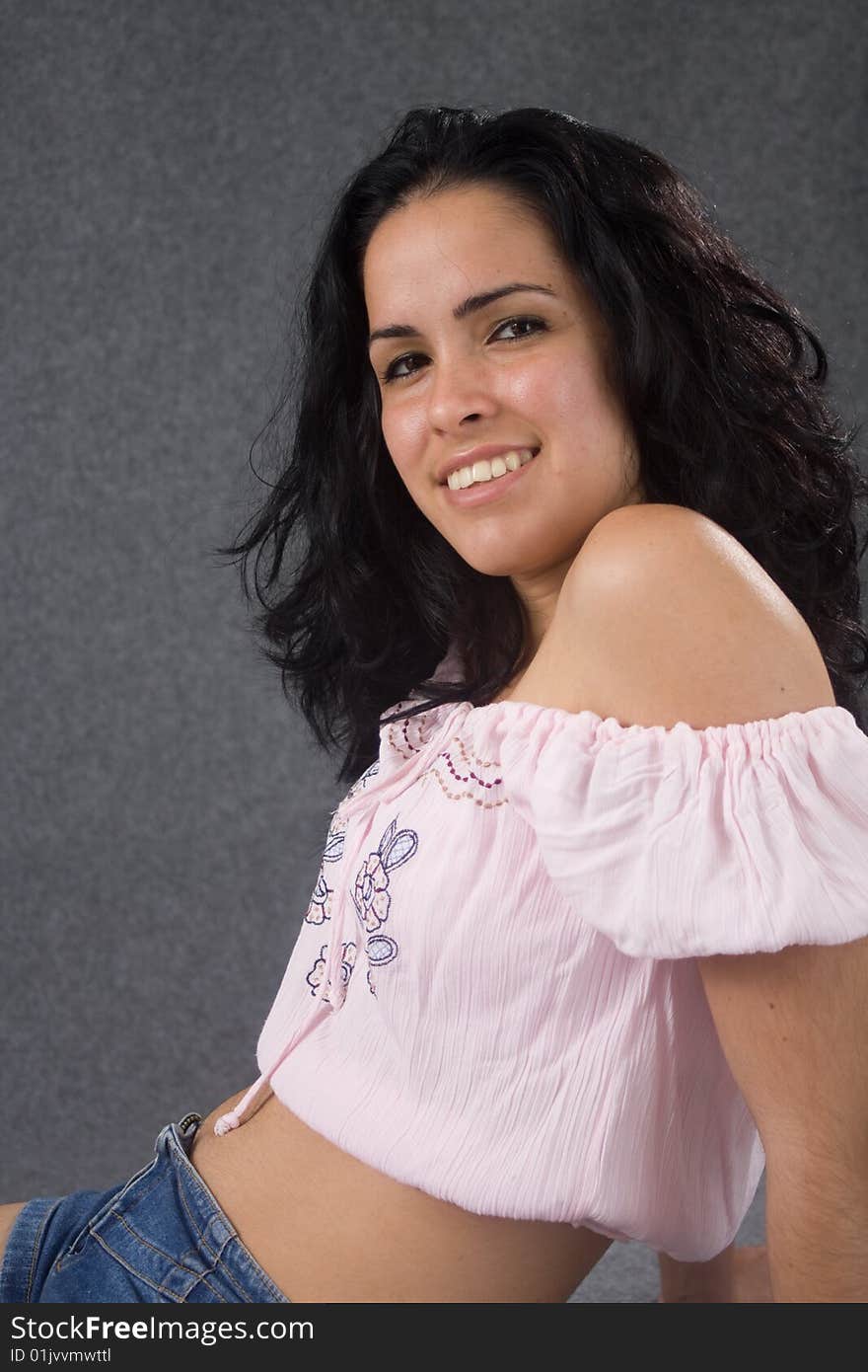 Side sitting girl with pink blouse smiling