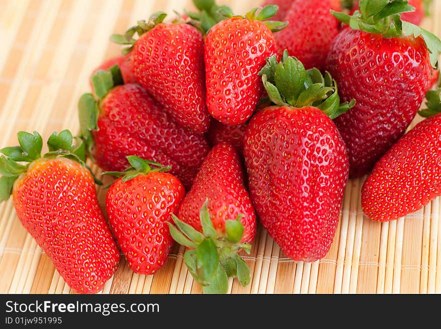 Close-up of fresh strawberries on a bamboo mat. Close-up of fresh strawberries on a bamboo mat