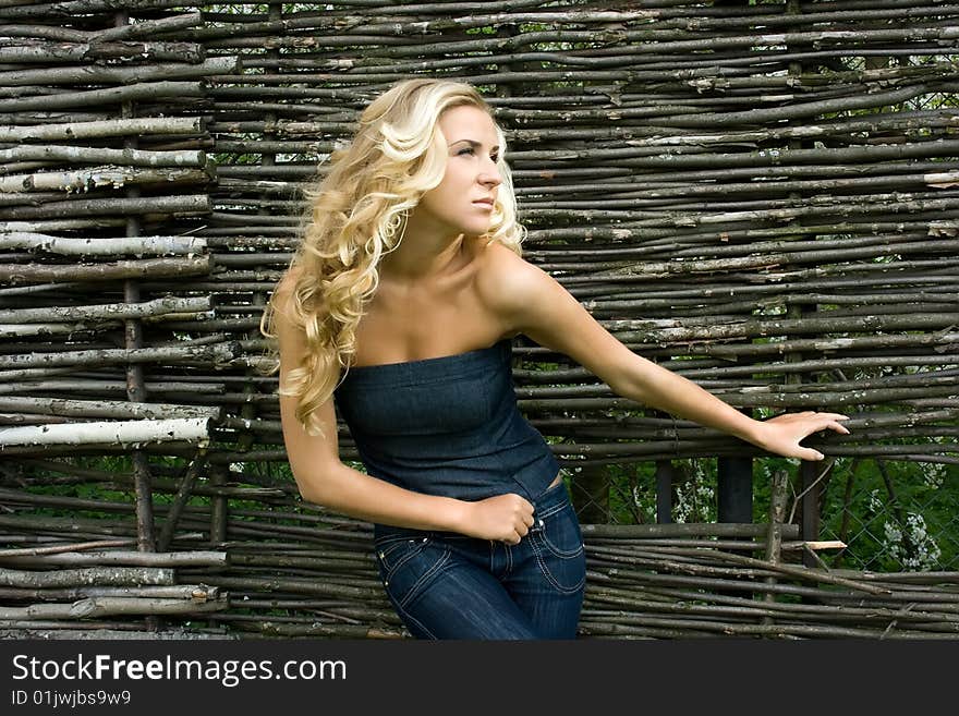 Young blonde girl standing at the fence