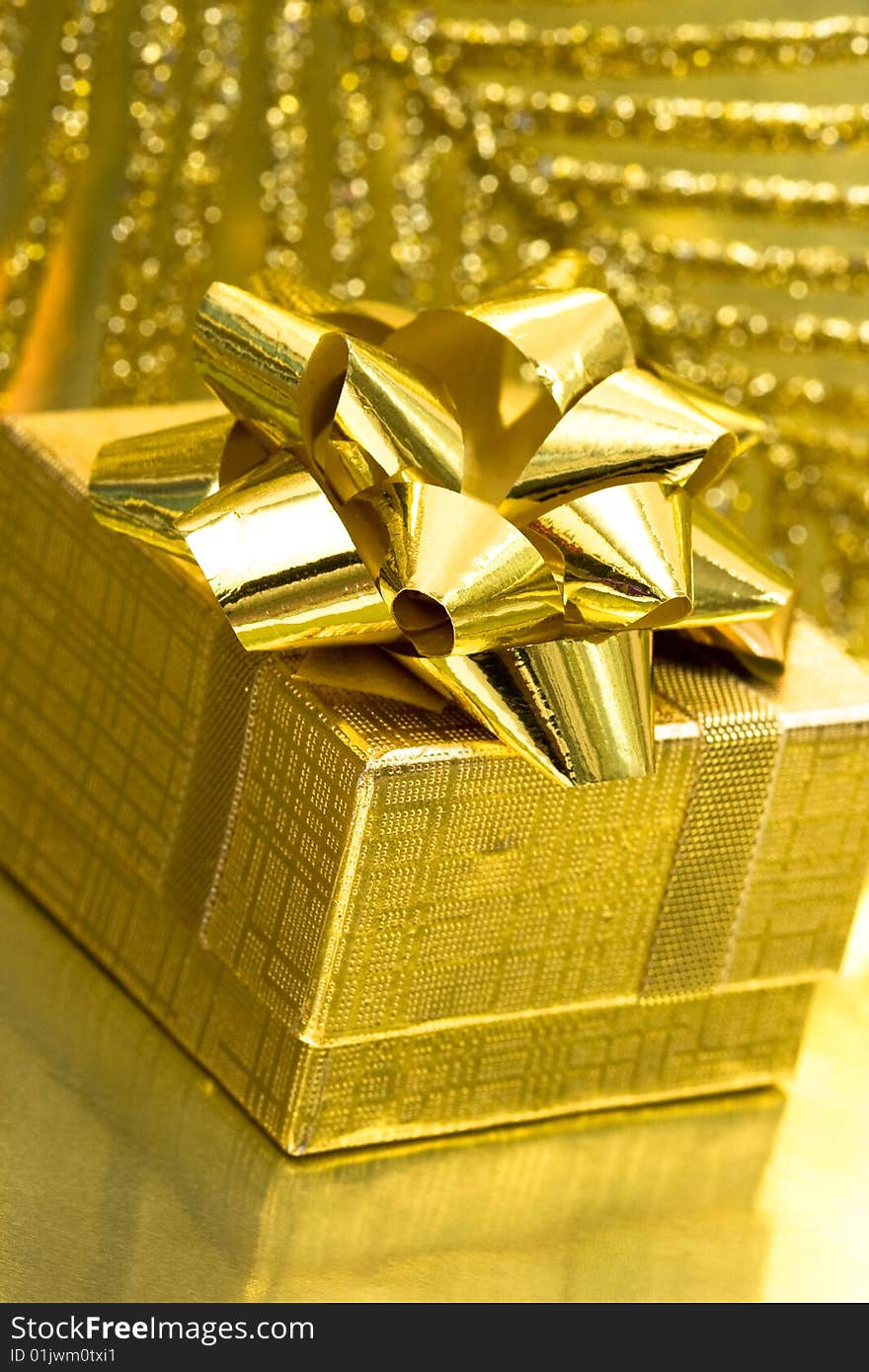 Gift box on golden background with leaf