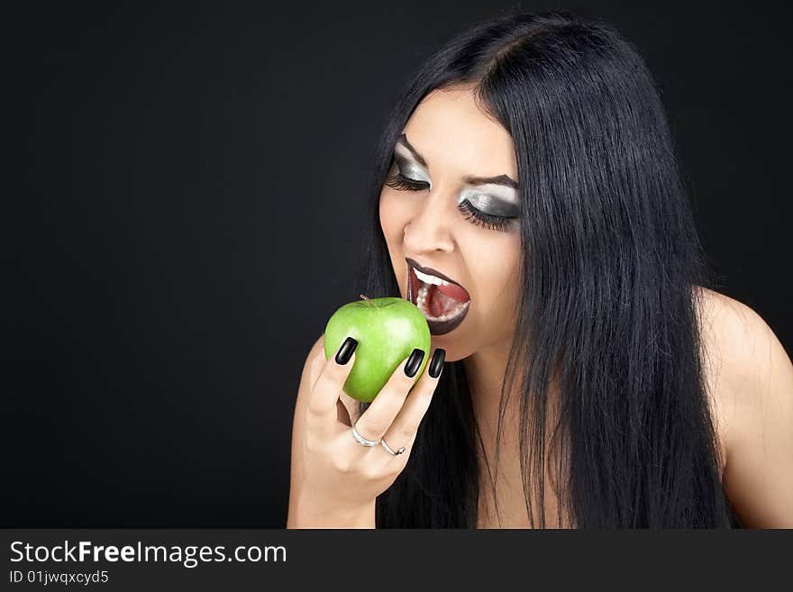 Brunette eating a green apple. Brunette eating a green apple