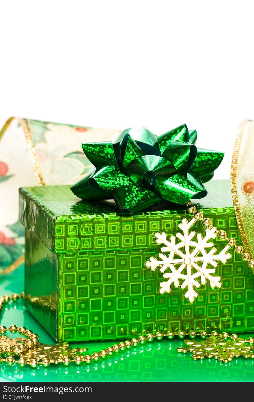 Green gift box and snowflake with ribbon