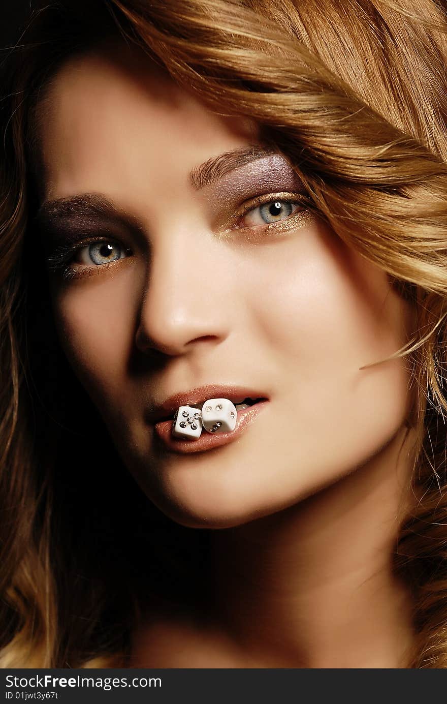 Fashion girl portrait with dice in her mouth. Fashion girl portrait with dice in her mouth