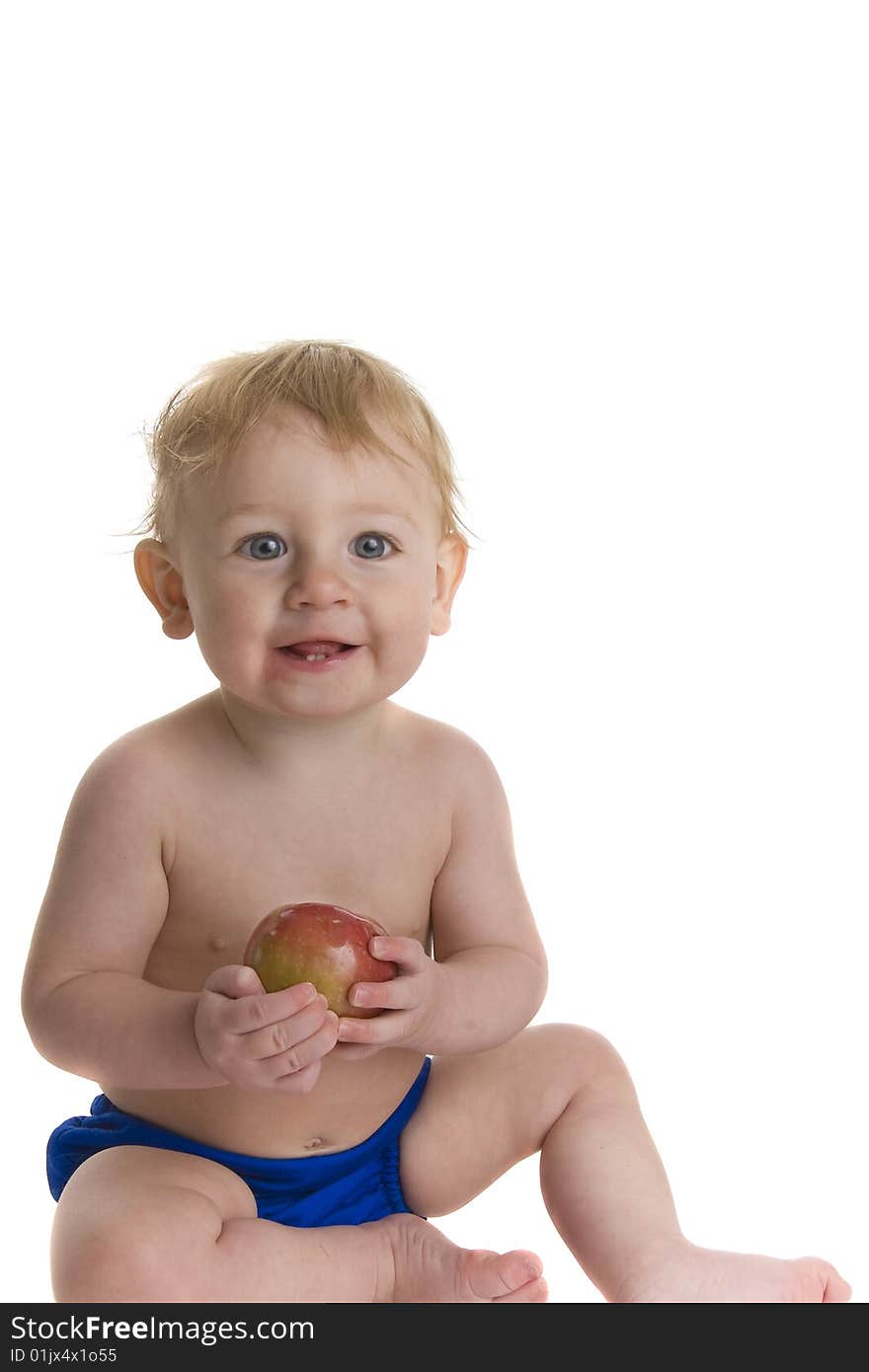 Happy baby holds and eats apple. Happy baby holds and eats apple