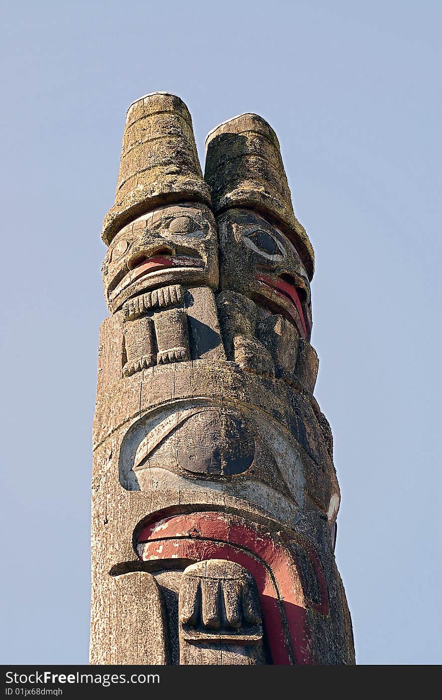 Pacific northwest totem pole against blue sky