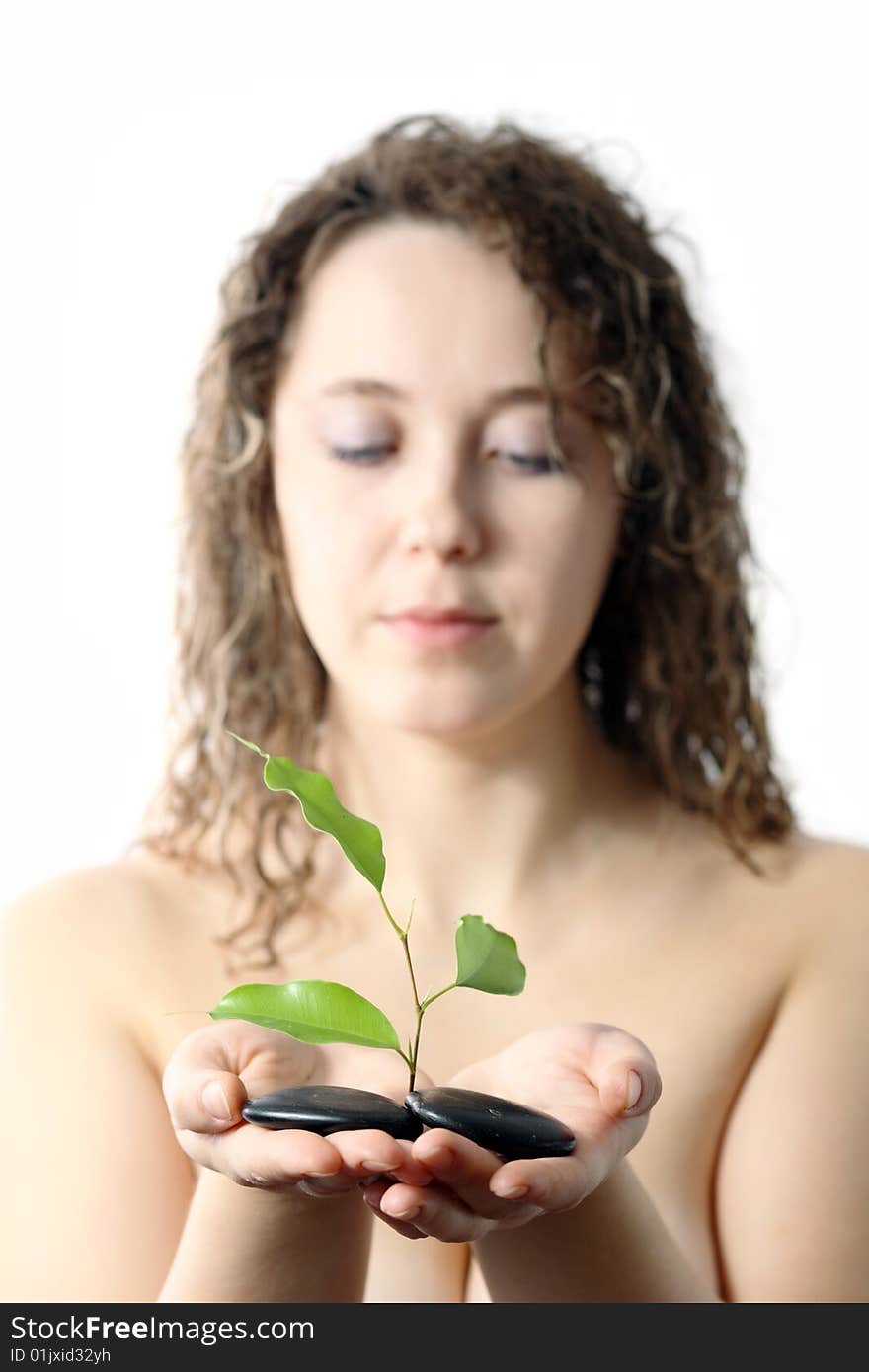 Stock photo: an image of a girl with plant and stones in her hands. Stock photo: an image of a girl with plant and stones in her hands