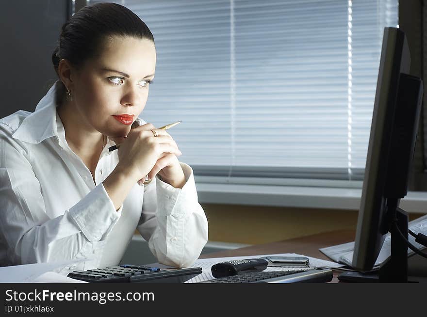 Woman in the evening sits at office. Woman in the evening sits at office