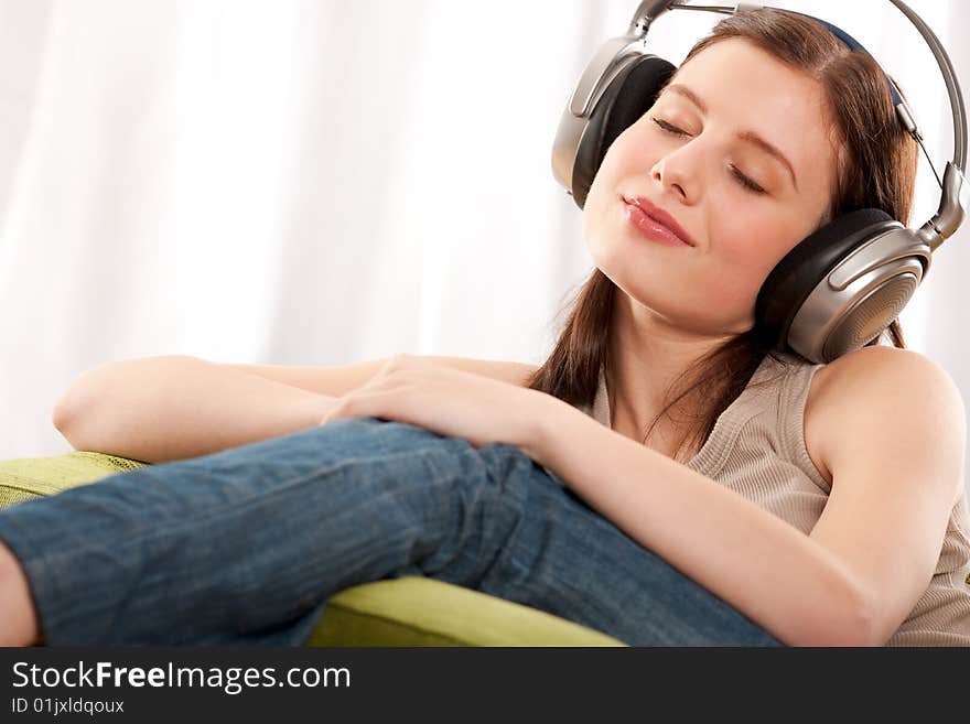 Young brunette enjoying music in the living room. Young brunette enjoying music in the living room