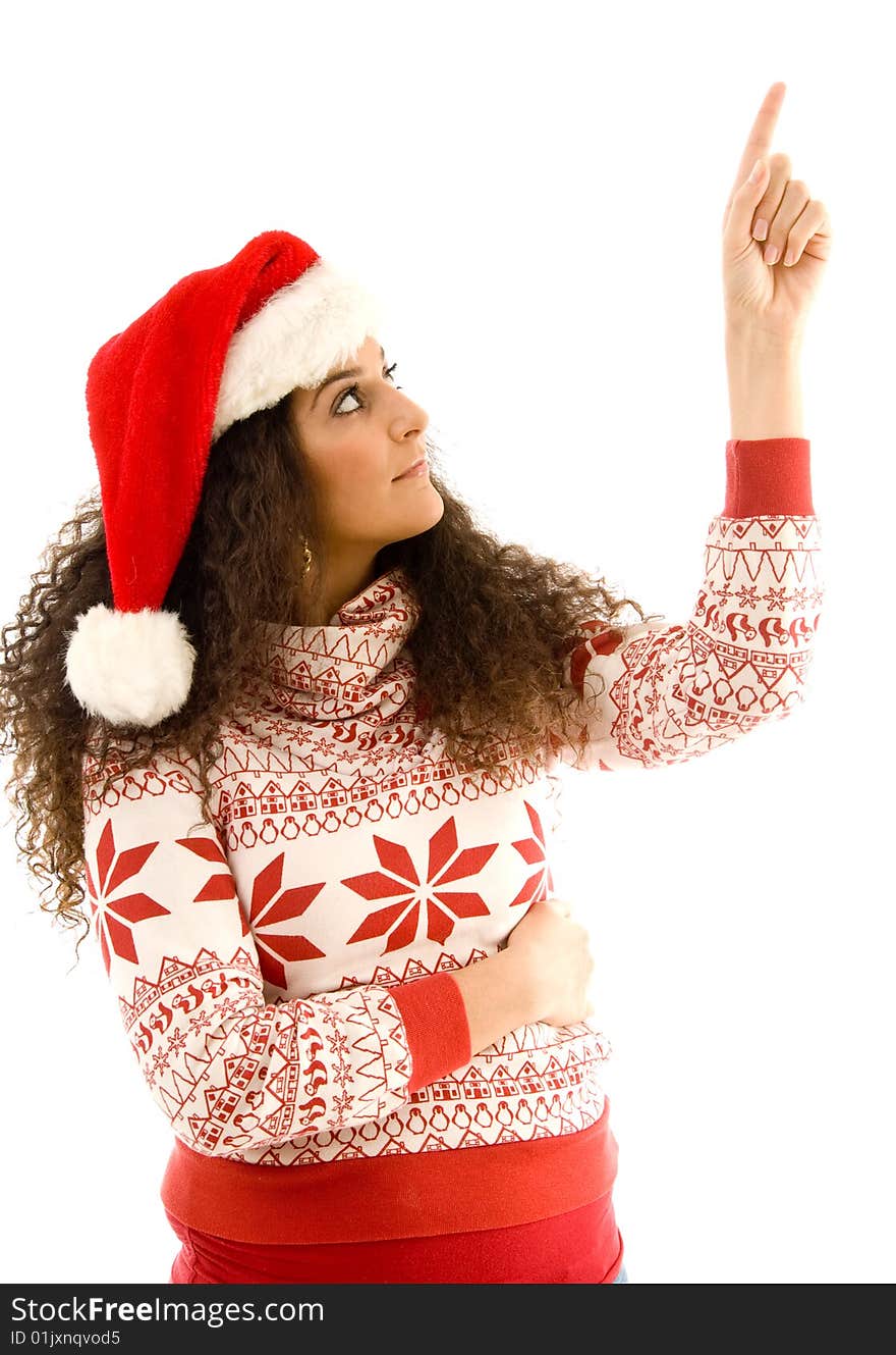 Cute young woman wearing red christmas hat and pointing upwards on an isolated white background