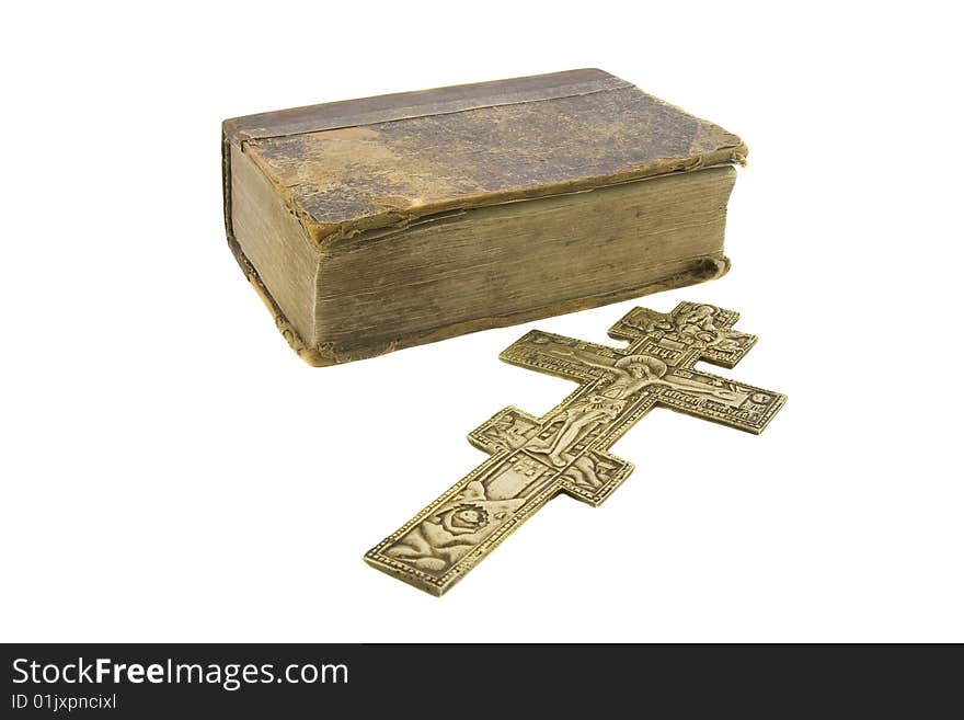 Very old vintage bible and big church cross near to it isolated over white background