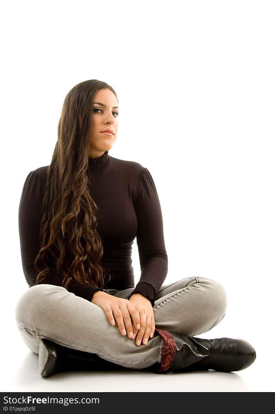 Fashionable woman sitting on the floor and looking sideways with white background