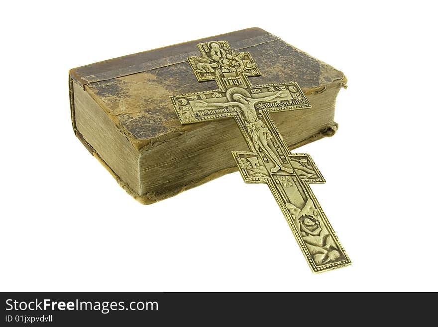 Very old vintage bible and big church cross near to it isolated over white background