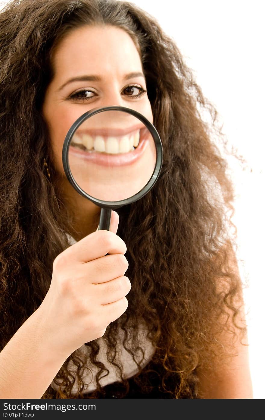 Young woman holding magnifier and showing her magnified teeth