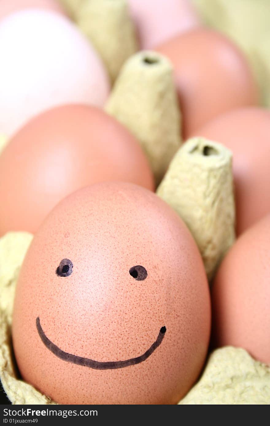 Eggs in a carton one with a smiling face