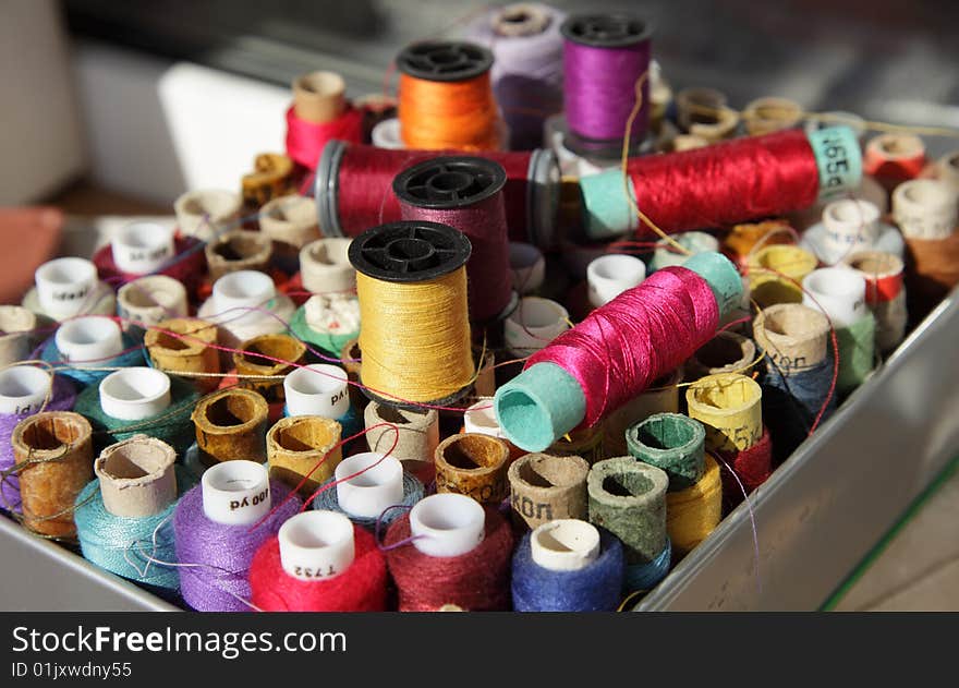 Coils with multi-coloured threads for sewing are packed in a box