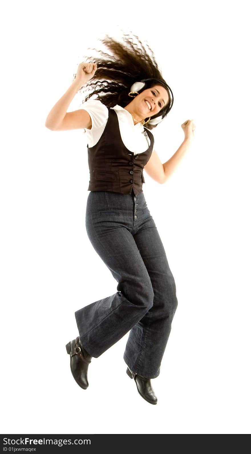 Beautiful female enjoying music and jumping against white background