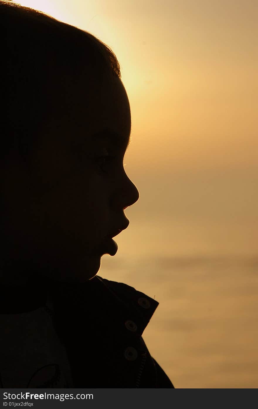 A child stay in front of the sea sunset. A child stay in front of the sea sunset