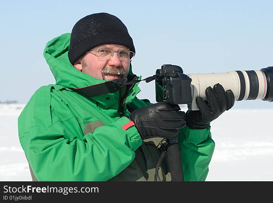 Photographer on  winter assignment with zoom lens. Photographer on  winter assignment with zoom lens