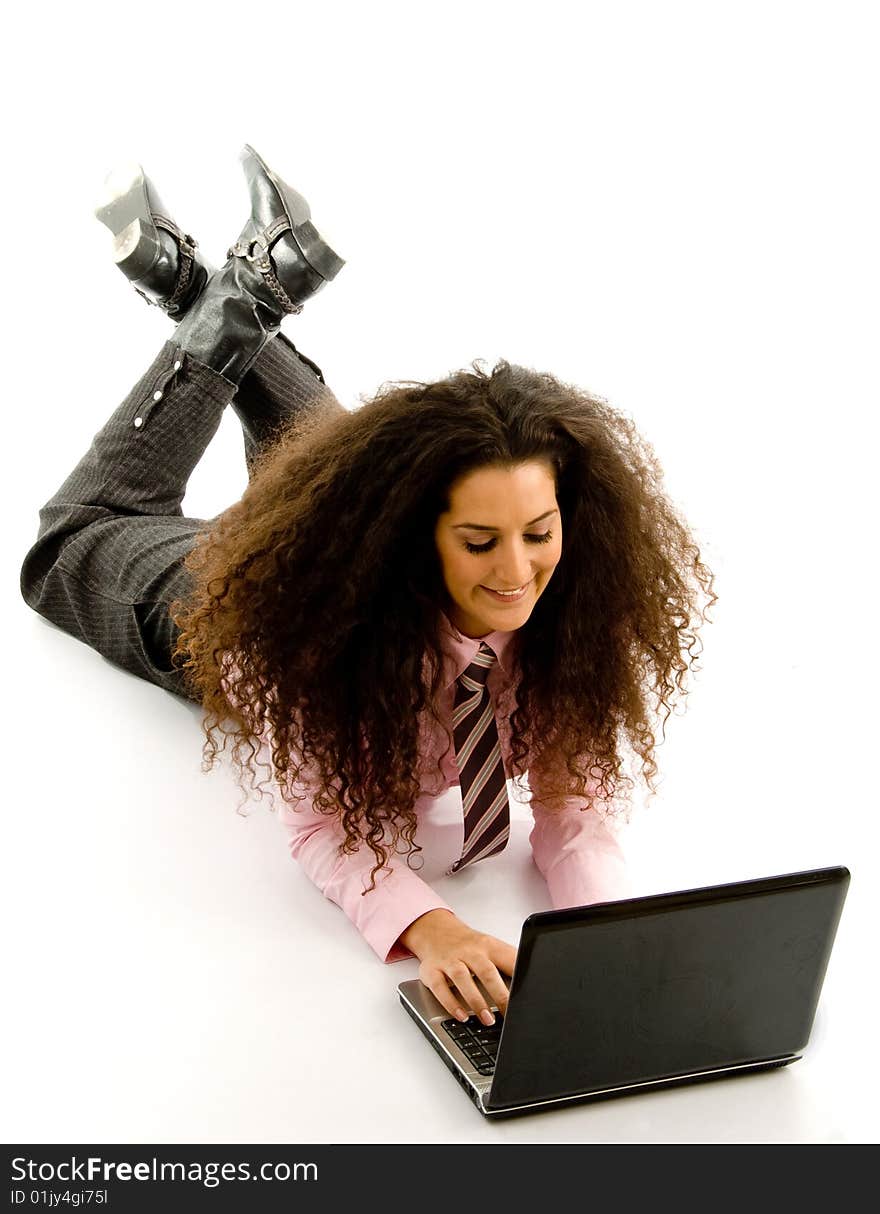 Young female lying on floor working on laptop with white background