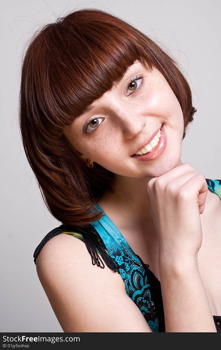 Laughing girl in a dress on a gray background