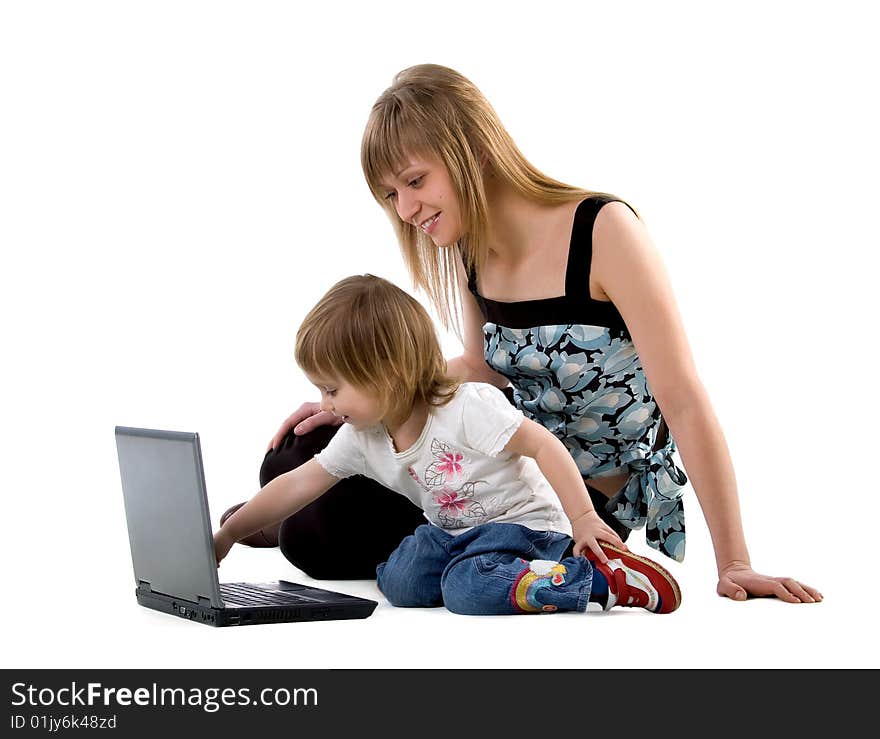 Little girl and her mother sits near laptop