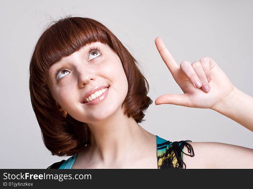 Laughing girl in a dress on a gray background