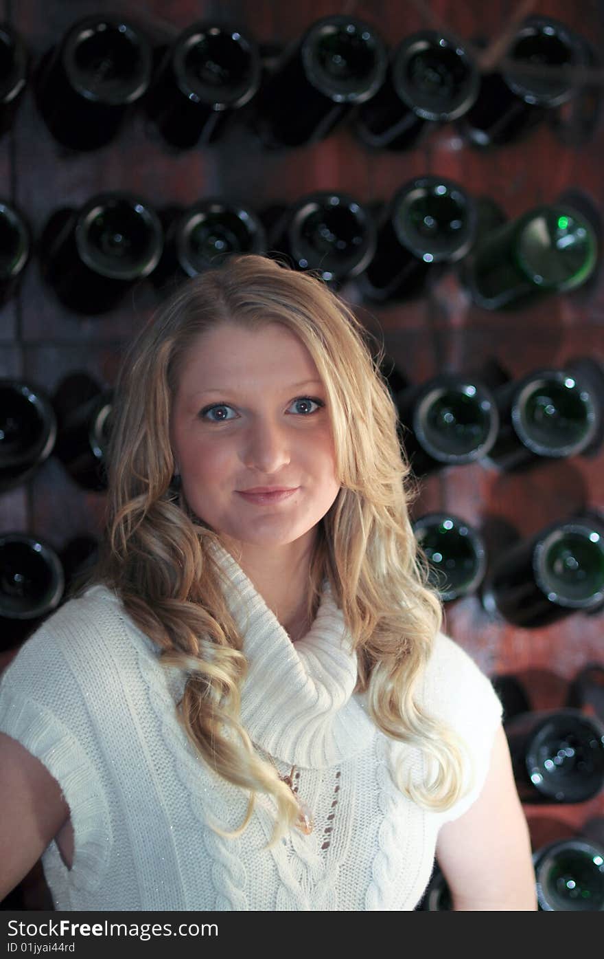 Attractive bond teen in front of wine rack. Attractive bond teen in front of wine rack