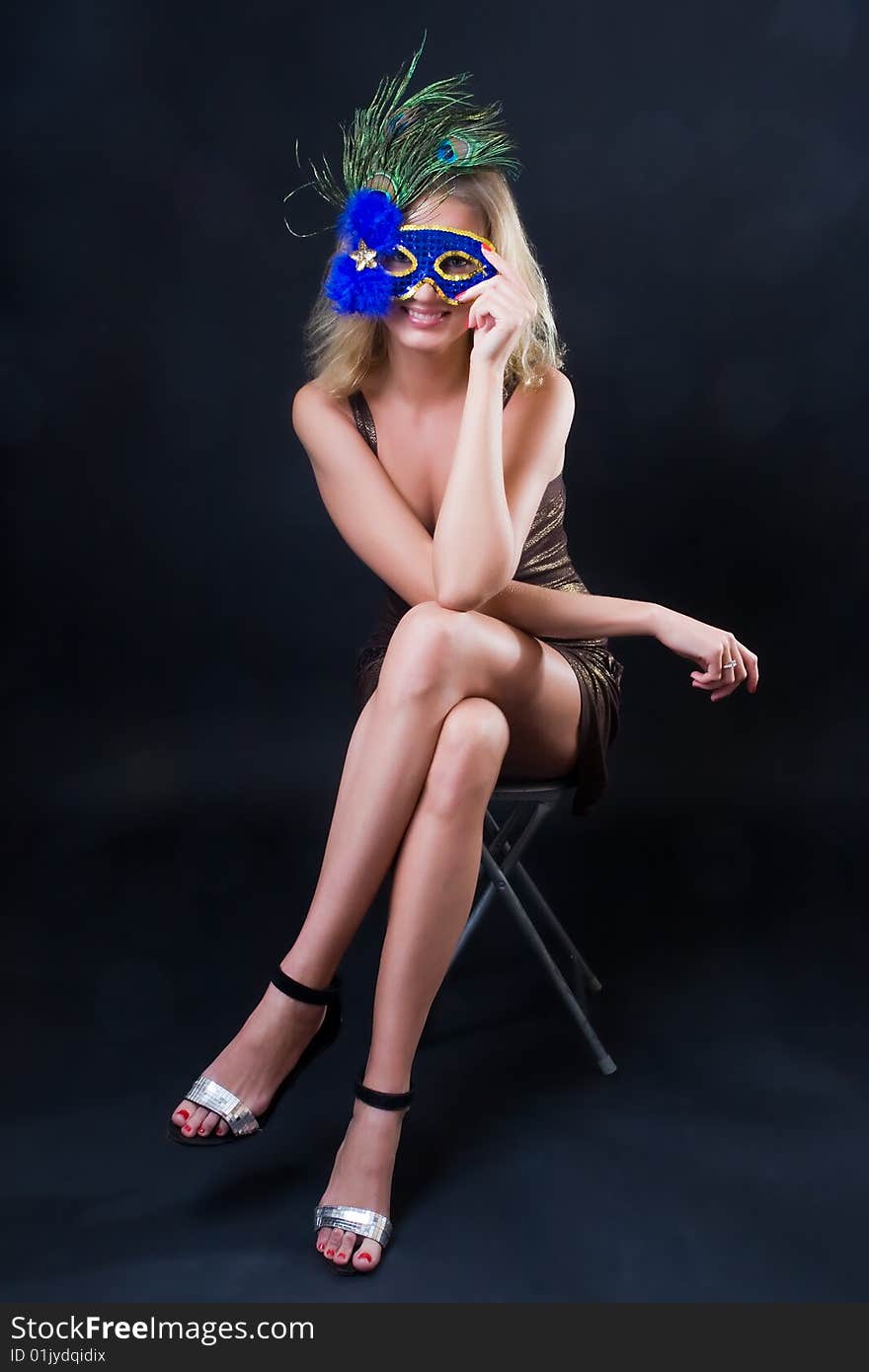 Beautiful girl in carnival mask against a dark background. Beautiful girl in carnival mask against a dark background