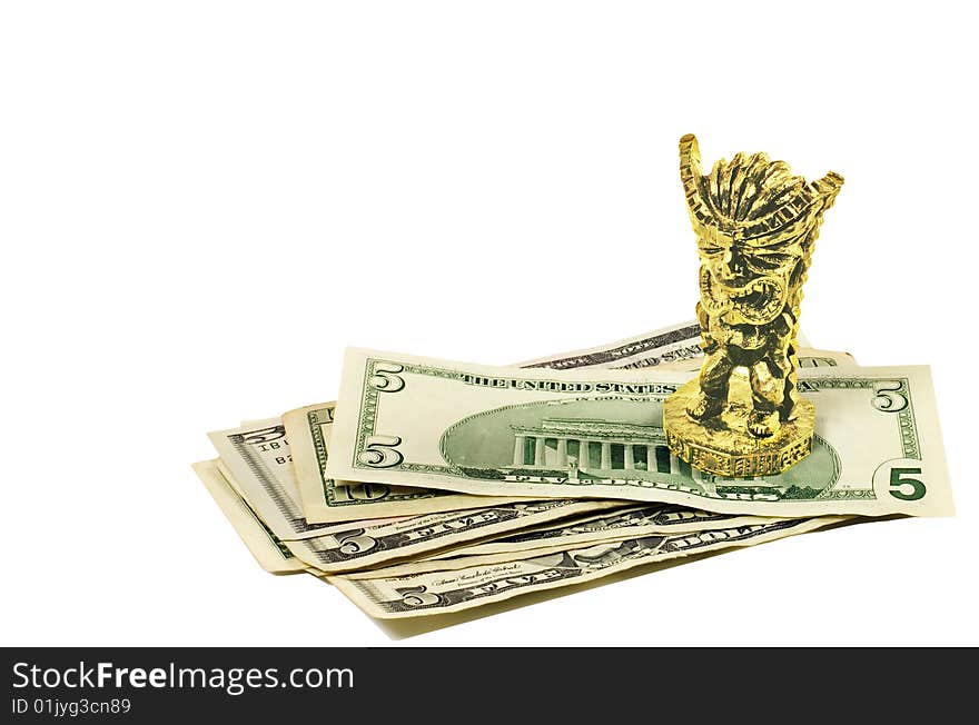 A golden figurine of Hawaiian God of money on a stack of US dollars. Isolated on white. A golden figurine of Hawaiian God of money on a stack of US dollars. Isolated on white