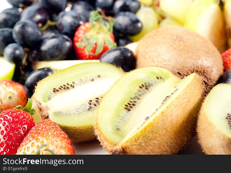 Assorted fresh fruits background including strawberry, apple, kiwi and black and green grape