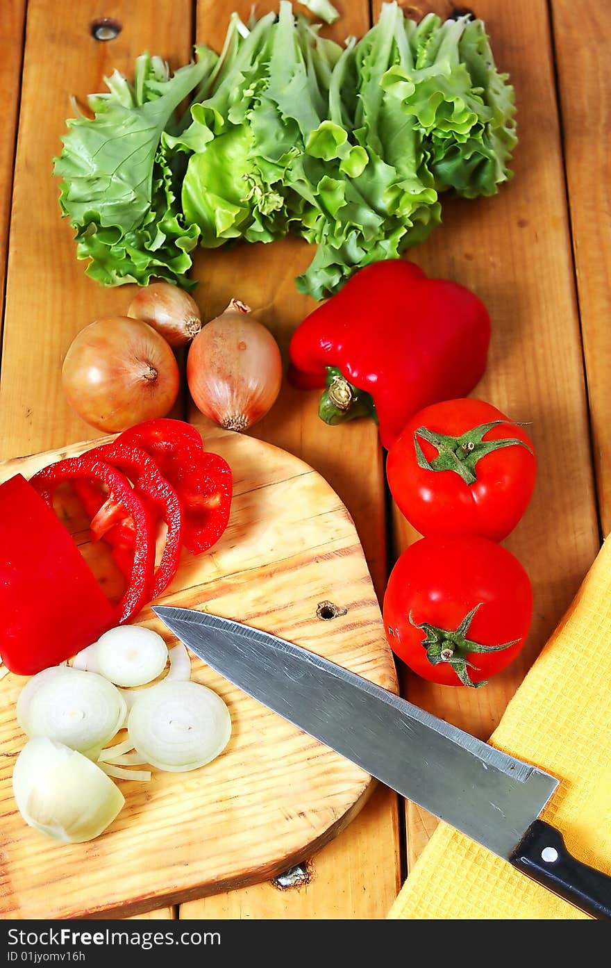 The prepared fresh vegetables for salad on a wooden table