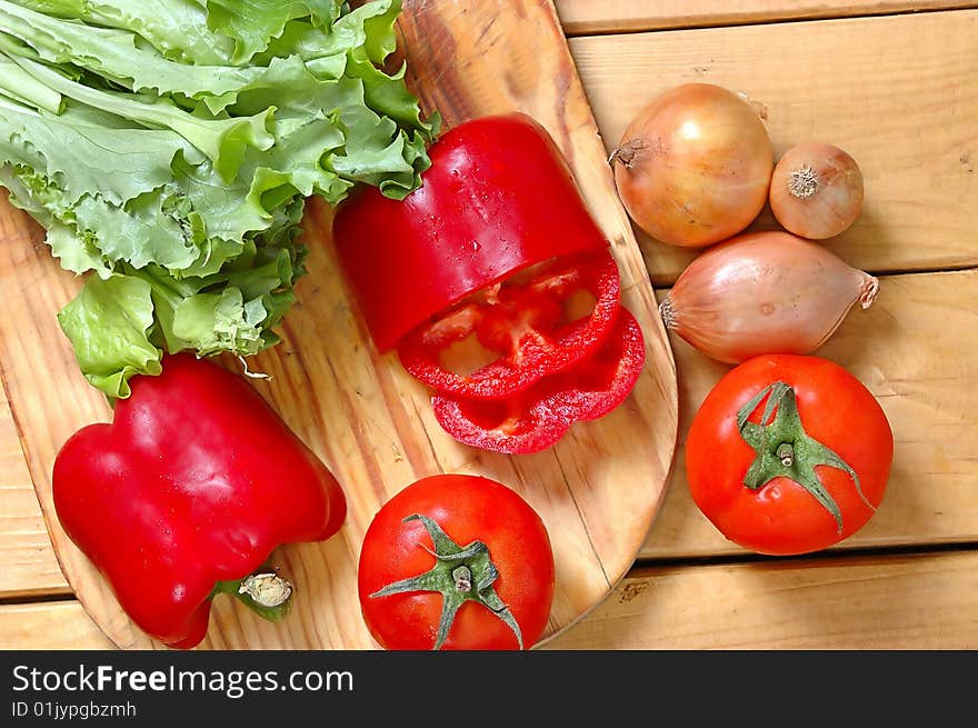 The prepared fresh vegetables for salad on a wooden table