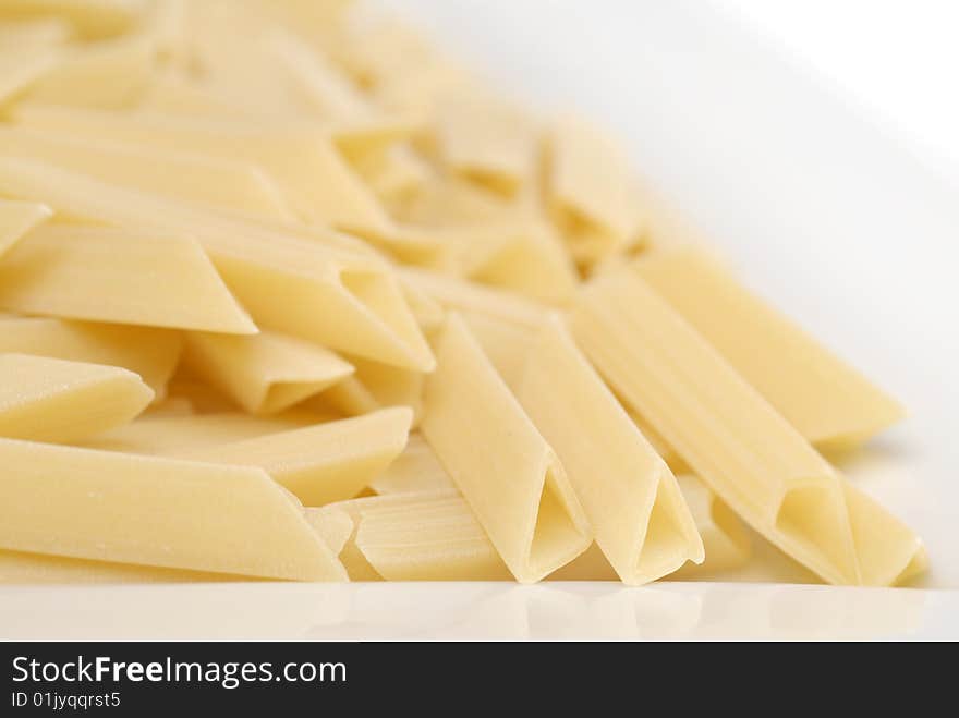 Raw macaroni on the white table