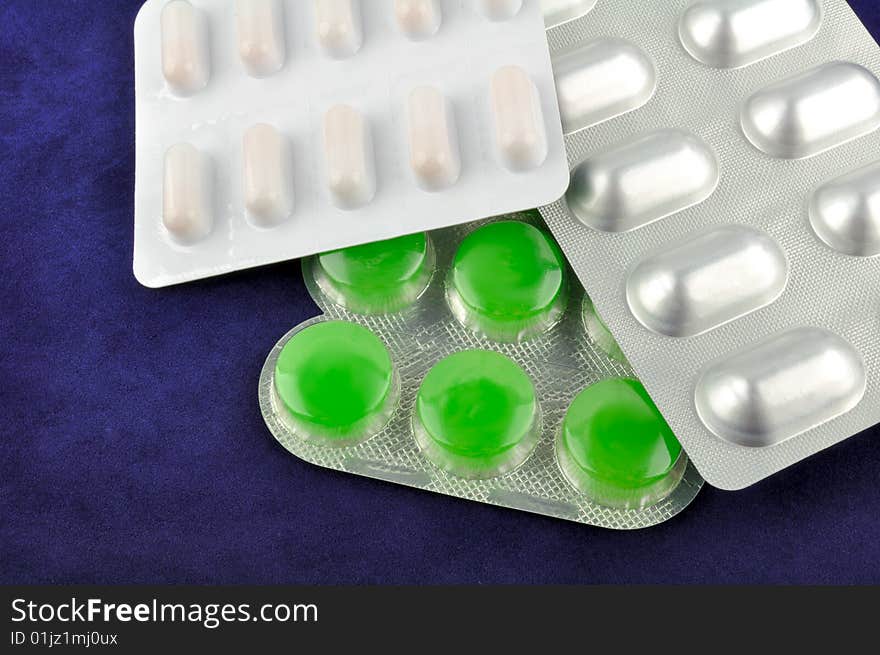 Various tablets (medicines) on the blue background