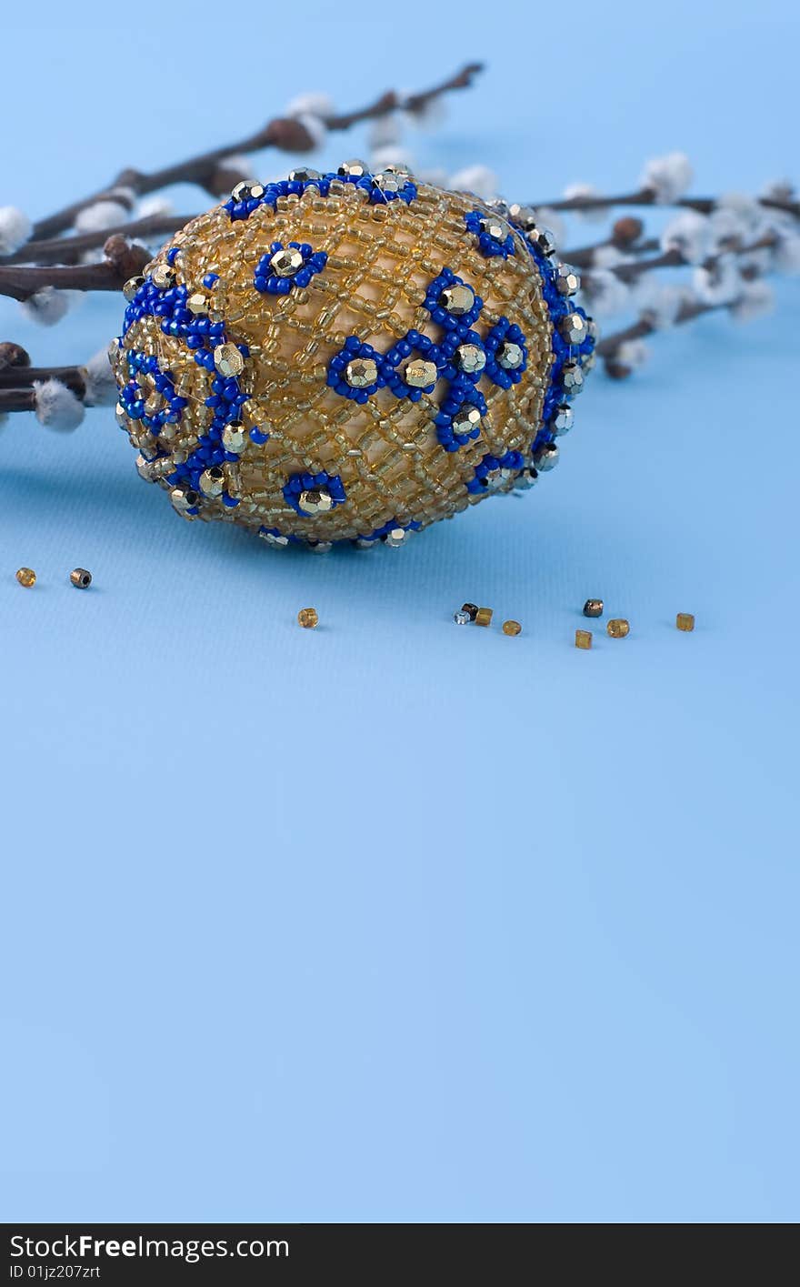 Bead easter egg and sprigs of pussy-willow on a blue background. Bead easter egg and sprigs of pussy-willow on a blue background