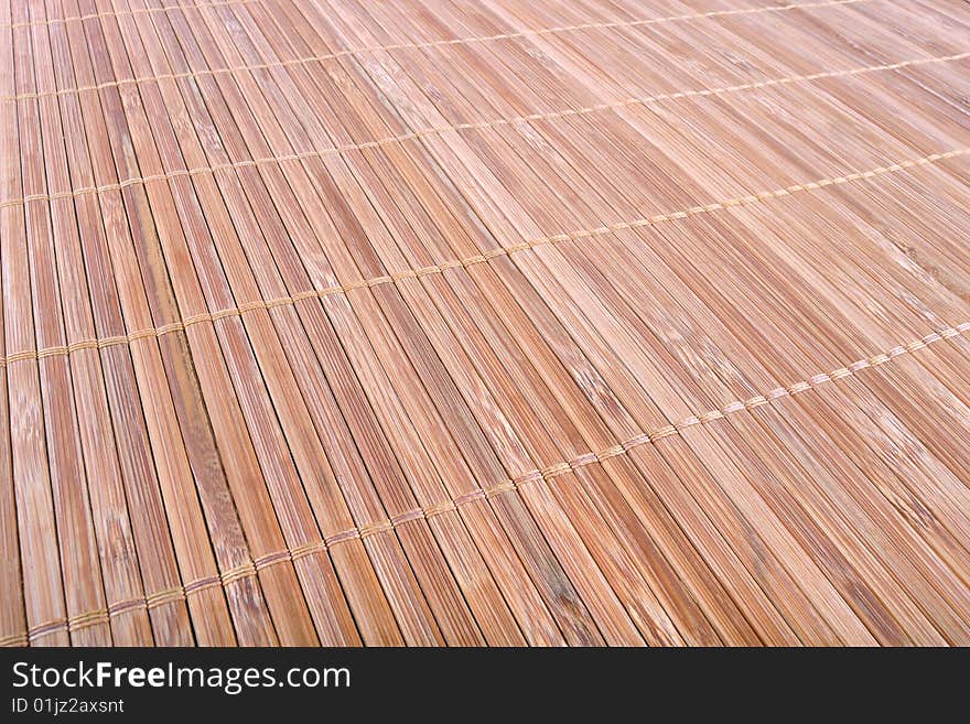 Light brown mat of bamboo strips bound together as a background