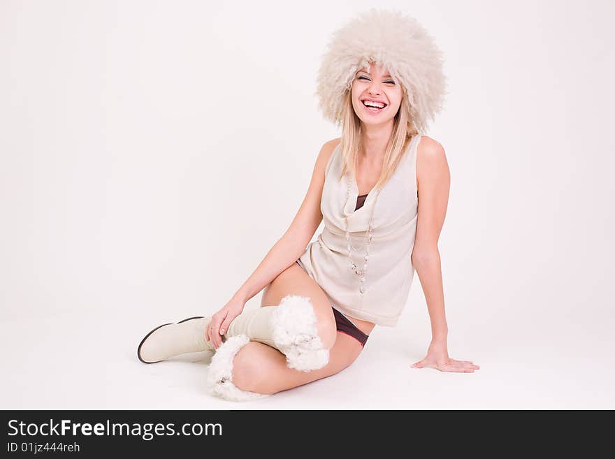 Laughing girl in furry hat, studio shot