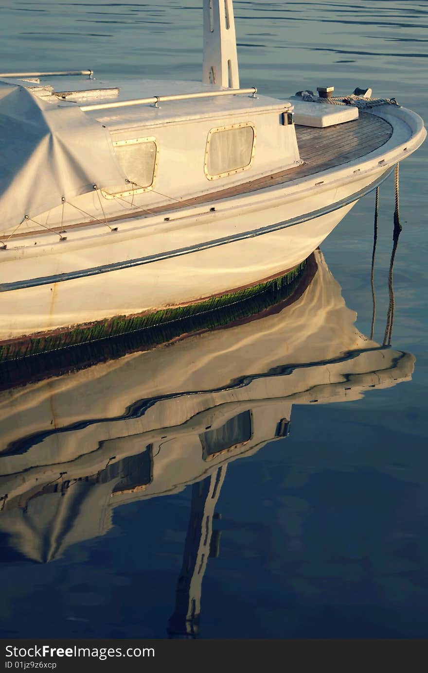 White boat and its reflection on sea surface. White boat and its reflection on sea surface.