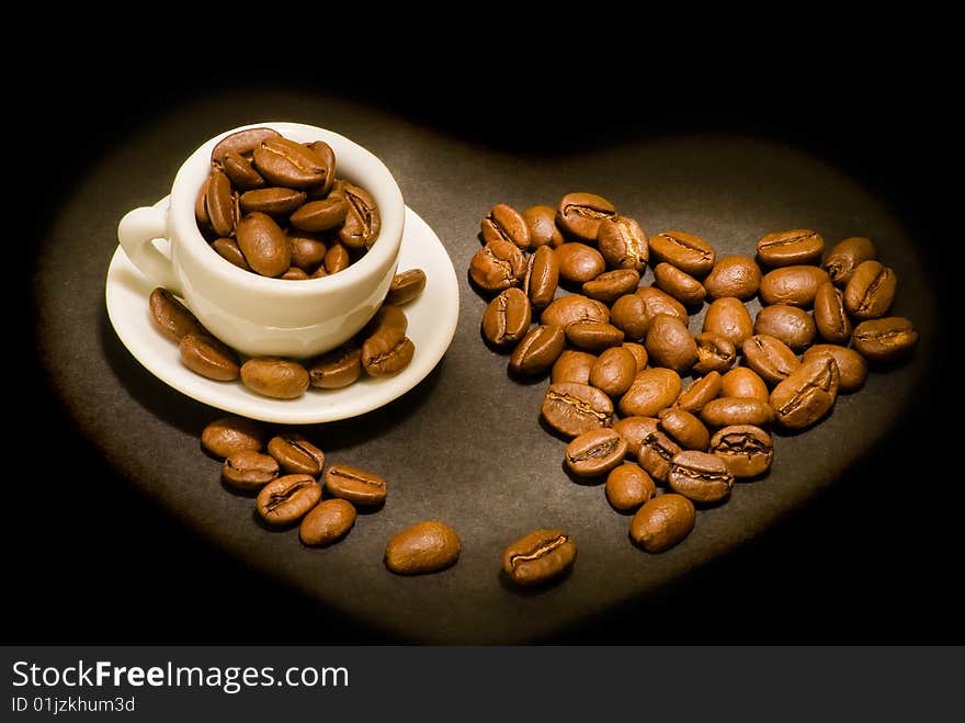 Heart from coffee beansand and coffee cup