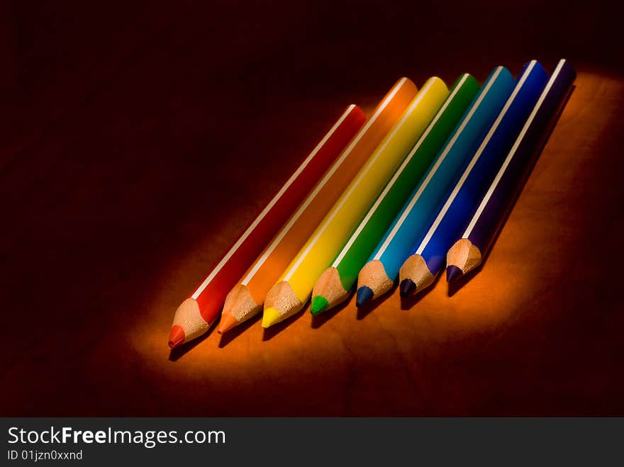 Colored pencils against a black background. Colored pencils against a black background