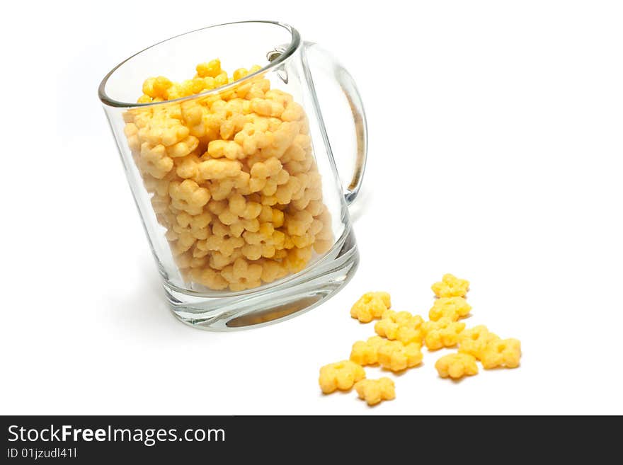 Glass cup full dry morning meal, disposit flakes on white background