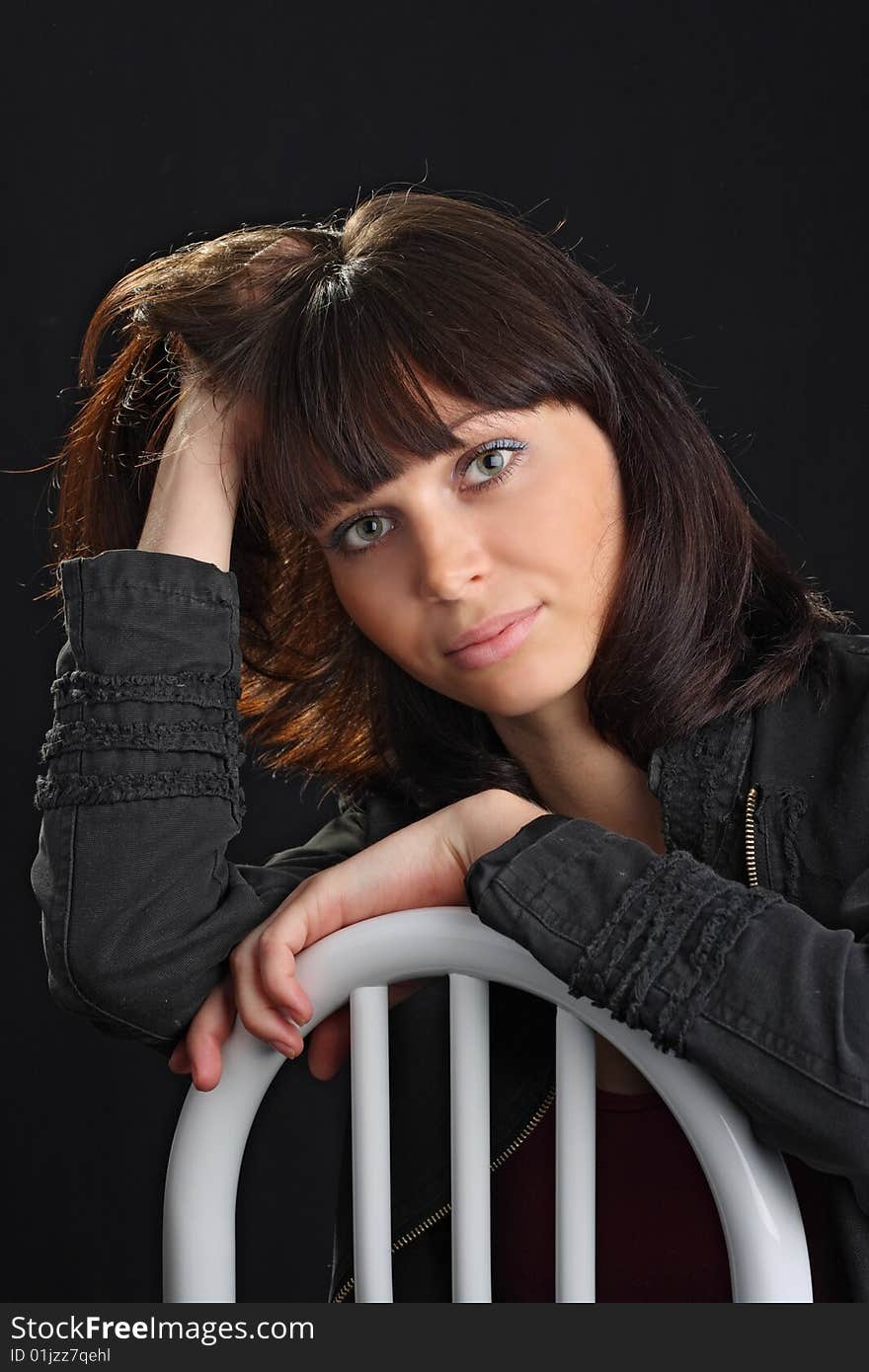 Young beautiful woman sit on chair on black background