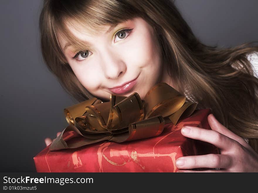 Happy girl with gift. Studio shot.