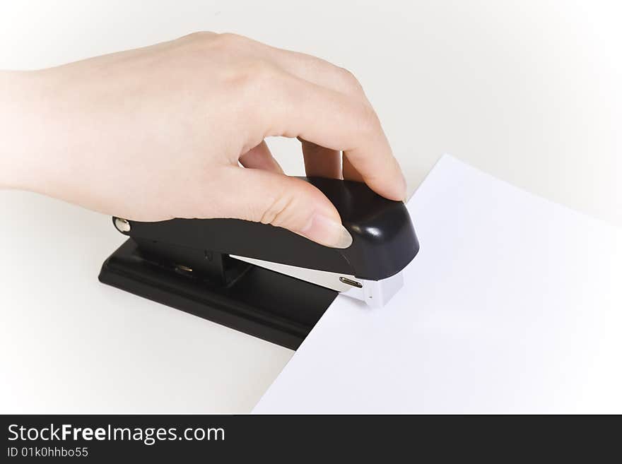 Hand pushing down an stapler isolated on white. Hand pushing down an stapler isolated on white.