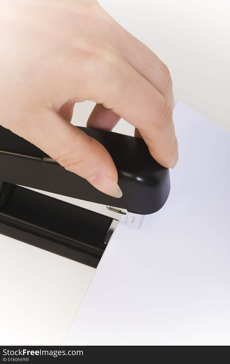 Hand pushing down an stapler isolated on white. Hand pushing down an stapler isolated on white.