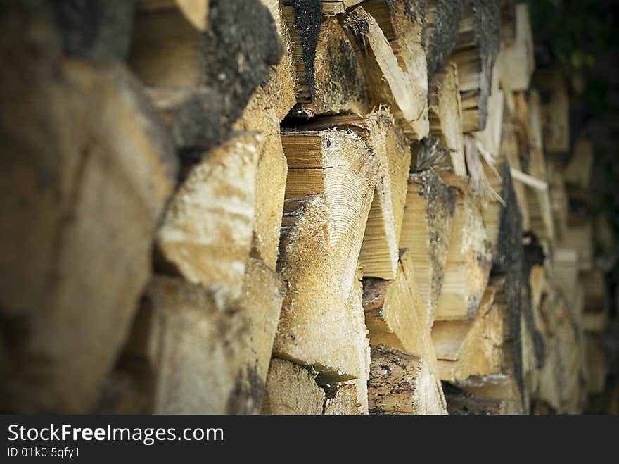 Firewood of yellow colour neatly stacked in a pile