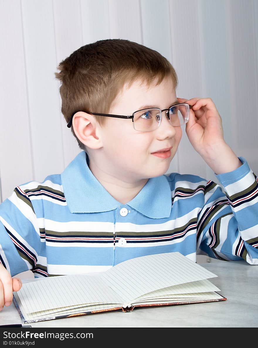 The little boy doing homework on the table. The little boy doing homework on the table